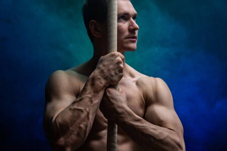 Muscular male circus artist with Cord Lisse on black an smoked backgroundの写真素材