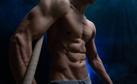 Muscular male circus artist with Cord Lisse on black an smoked backgroundの写真素材