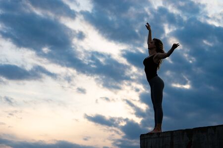 Young woman dancer on outdoor sunrise background. Concept of freedom and happy lifestyleの写真素材