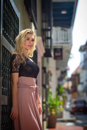 Beautiful woman with long dress walking alone at the colorful streets of the colonial walled city of Cartagena. Colombiaの写真素材
