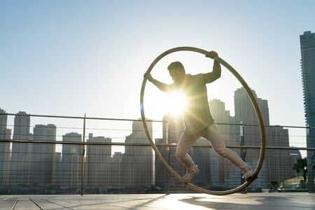 Cyr Wheel artist with cityscape background of Dubai during sunset.の写真素材