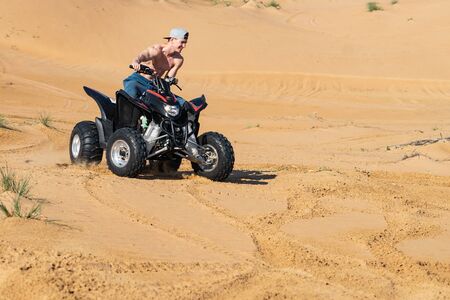 Muscular Man topless Riding Atv In the Desert.の写真素材