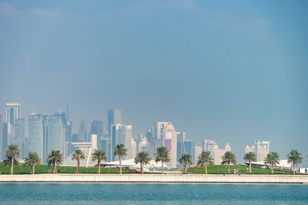 Panoramic view of modern skyline of Doha with Palms foreground. Concept of healthy environmentの写真素材