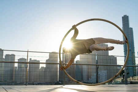 Cyr Wheel artist with cityscape background of Dubai during sunsetの写真素材