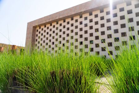 Doha, Qatar - View of blurred building in Education city with green grass foregroundの写真素材