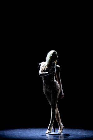 Silhouette of Beautiful good shaped blond woman singing on the stage with microphoneの写真素材
