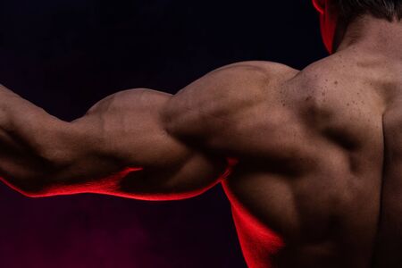 Muscular man showing muscles isolated on the black background.healthy lifestyleの写真素材