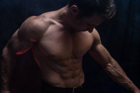 Muscular man showing muscles isolated on the black background.healthy lifestyleの写真素材