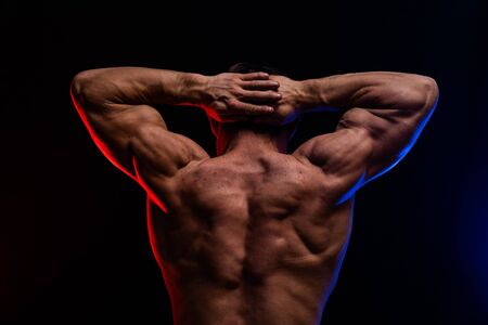 Muscular man showing muscles isolated on the black background.healthy lifestyleの写真素材