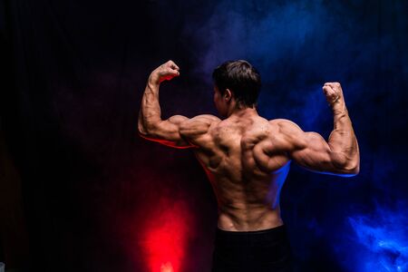 Muscular man showing muscles isolated on the black background.healthy lifestyleの写真素材