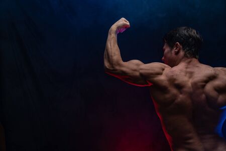 Muscular man showing muscles isolated on the black background.healthy lifestyleの写真素材