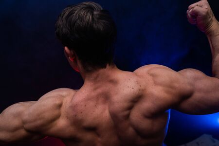 Muscular man showing muscles isolated on the black background.healthy lifestyleの写真素材
