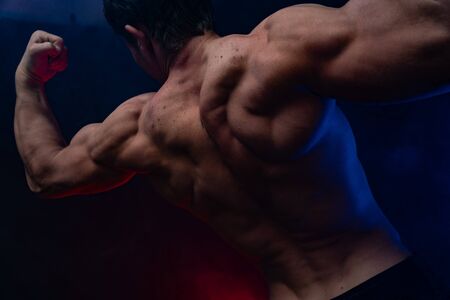 Muscular man showing muscles isolated on the black background.healthy lifestyleの写真素材