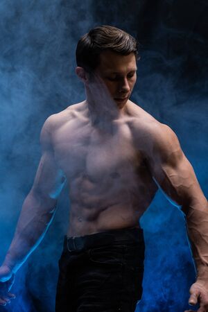 Muscular man showing muscles isolated on the black background.healthy lifestyleの写真素材