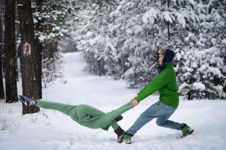 Acrobatic duo making nice pose in the snowy forest during the winter. Concept relationship, happiness and trustの写真素材