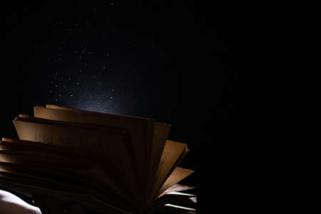 Vintage open Book Glows In The Darkness. Concept of self-education, knowledge and intellectの写真素材