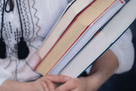 Closeup of Hands Holding A Stack Of Books. Concept of education and studentsの写真素材