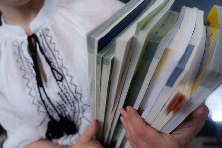 Closeup of Hands Holding A Stack Of Books. Concept of self-isolation self-education, and quarantineの写真素材