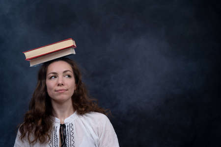 Sad female student reading with lots of books for the exam. Concept homeschoolingの写真素材