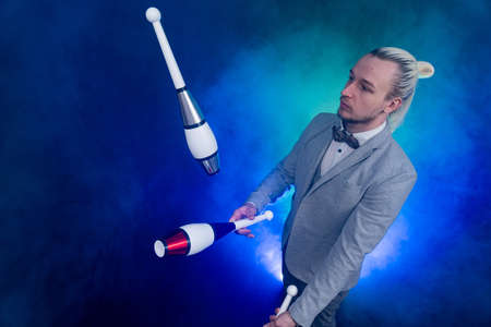 Man wearing formal suit juggling with clubs. Management, control and successの写真素材