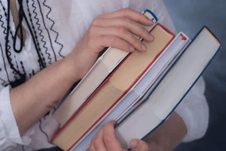 Closeup of Hands Holding A Stack Of Books. Concept of education and studentsの写真素材