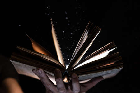 Vintage open Book Glows In The Darkness. Concept of self-education, knowledge and intellectの写真素材