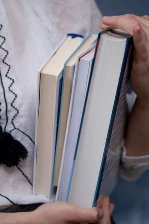 Closeup of Hands Holding A Stack Of Books. Concept of education and studentsの写真素材
