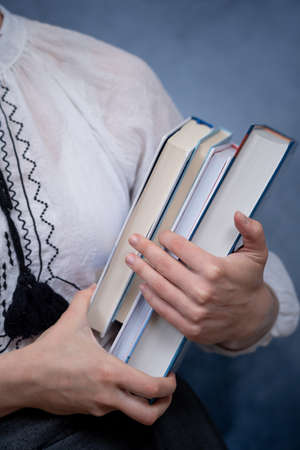 Closeup of Hands Holding A Stack Of Books. Concept of education and studentsの写真素材