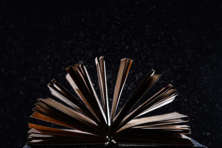 Open book on black isolated background. Concept of knowledge, wisdom and learningの写真素材