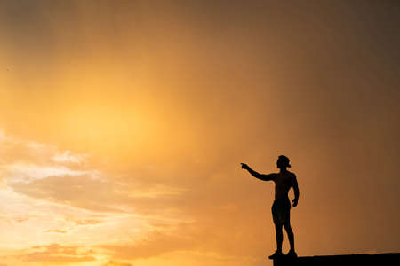 Silhouette of Man stepping from the edge during dramatic sunset. Concept goal, step forward and riskの写真素材