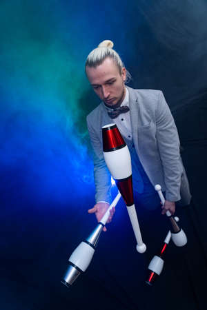 Man wearing formal suit juggling with clubs. Management, control and successの写真素材