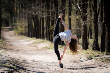 Flexible female gymnast in the forest. Concept of freedom and happinessの写真素材