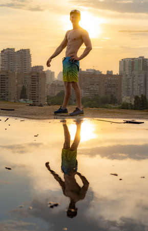 Muscular man with capping on the rooftop during sunset on cityscape backgroundの写真素材