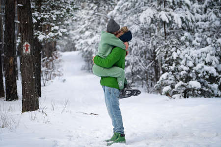 Couple kissing in the snowy park outdoor during the winter. Concept of happiness, trust and supportの写真素材