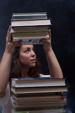 Girl surrounded by many books. Concept of wisdom, knowledge and self-educationの写真素材