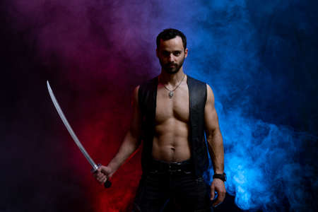 Ukrainian cossack posing with long sword isolated on black and smoked backgroundの写真素材