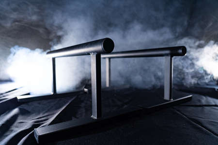 gymnastic bars for push-ups isolated on back and smoked backgroundの写真素材