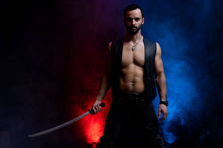 Ukrainian cossack posing with long sword isolated on black and smoked backgroundの写真素材