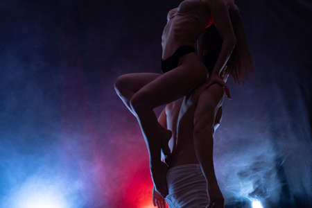 Silhouette of sexy woman in underwear seducing a guy with blue and red background. Concept of attraction, domination and sexualityの写真素材