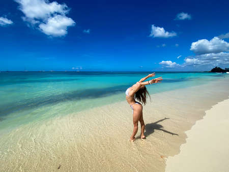 Sexy beautiful caucasian woman posing in white bikini at the sea coast. Exotic country travel and rest concept. Slim figure and sexy bodyの写真素材