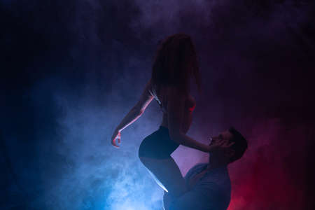 Silhouette of sexy woman in underwear seducing a guy with blue and red background. Concept of attraction, domination and sexualityの写真素材