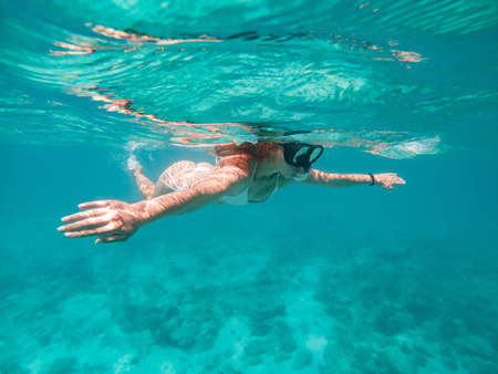 Woman swimming underwater. Concept about vacations, snorkeling and nature. Shot taken with underwater cameraの写真素材