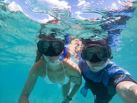 Man and Woman swimming with snorkeling mask. Concept about vacations, snorkeling and nature. Shot taken with underwater cameraの写真素材