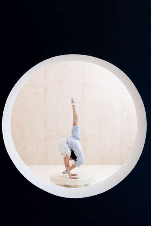 Flexible girl doing stretching and handstand in studio. concept of healthy lifestyle and yogaの写真素材
