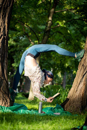 Young flexible woman read book on picnic. Concept of willpower, motivation and passionの写真素材