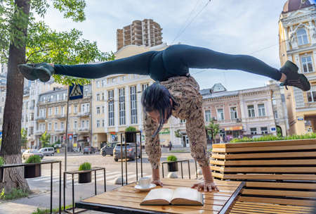 Woman drink coffee and read a book in cafe outdoor. Concept of education, studying and knowledgeの写真素材