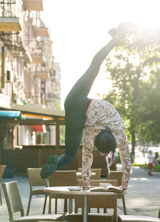 Woman drink coffee and read a book in cafe outdoor. Concept of self-development, goal and self-improvementの写真素材