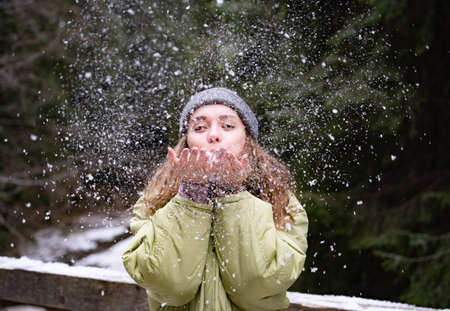 Woman Blowing Snow Outdoor on Winter background. Happiness and joy conceptの写真素材