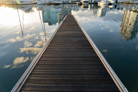 Wood empty pier to the sea at marina at sunrise with clouds in reflection. Travel and vacation conceptの写真素材