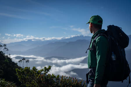 Man with backpack looking at mountain view. Travel and adventure concept.